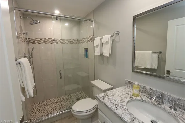 a bathroom with a granite countertop sink toilet and shower