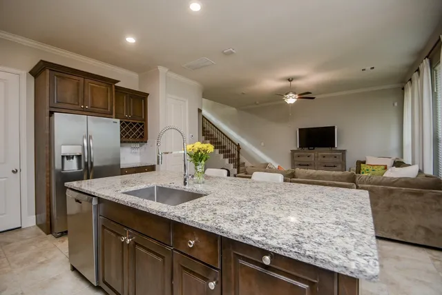 a kitchen with stainless steel appliances granite countertop a sink and a refrigerator