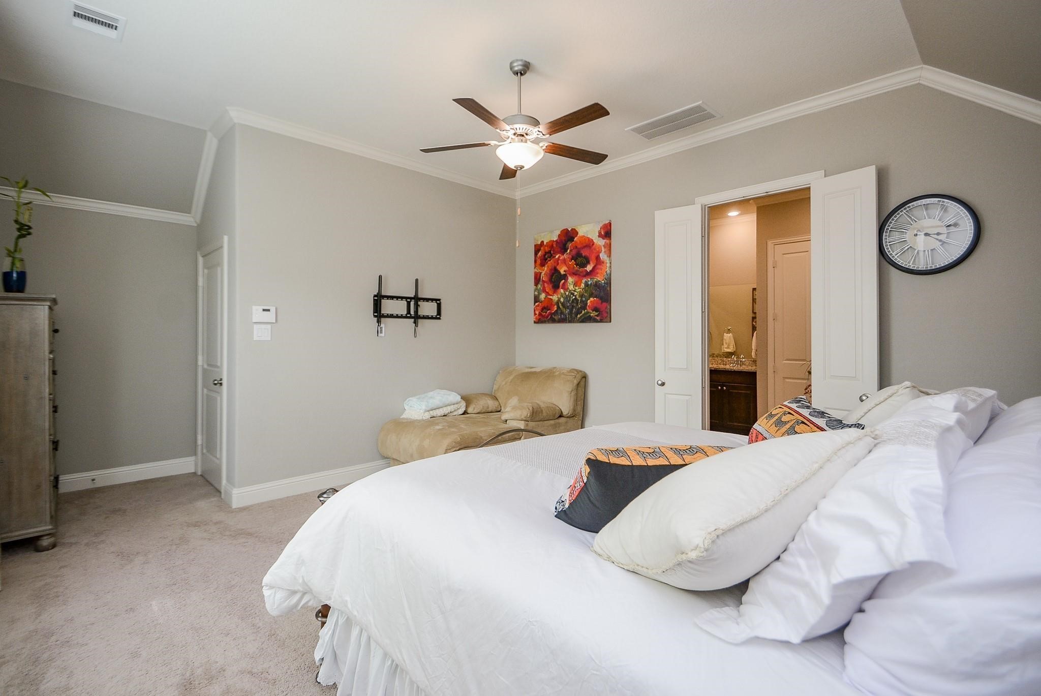 114 Silver Sky Street Conroe, TX 77304 - Photo 21 of 36 a bedroom with a bed and a chandelier
