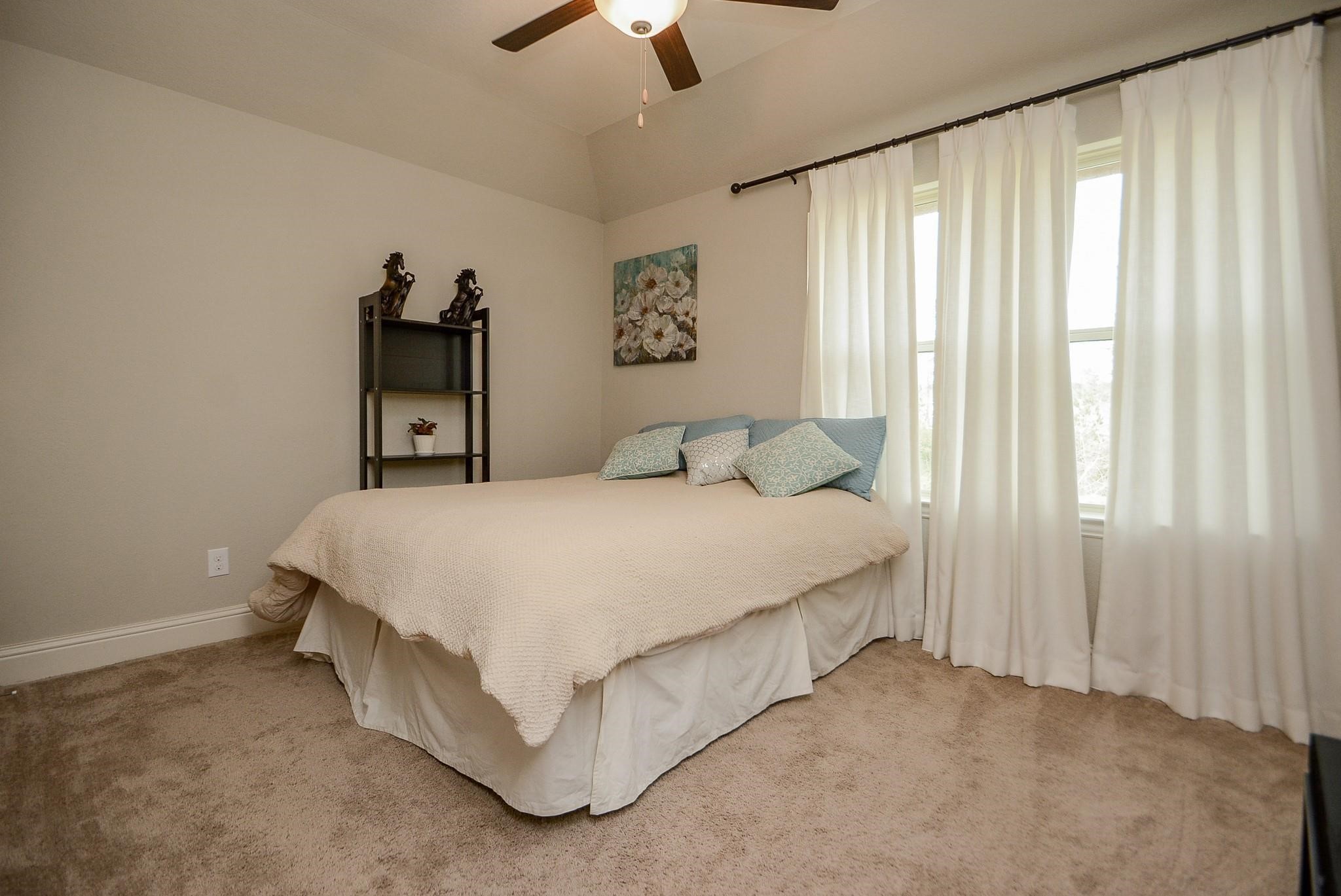 114 Silver Sky Street Conroe, TX 77304 - Photo 25 of 36 a bedroom with a bed and a chandelier