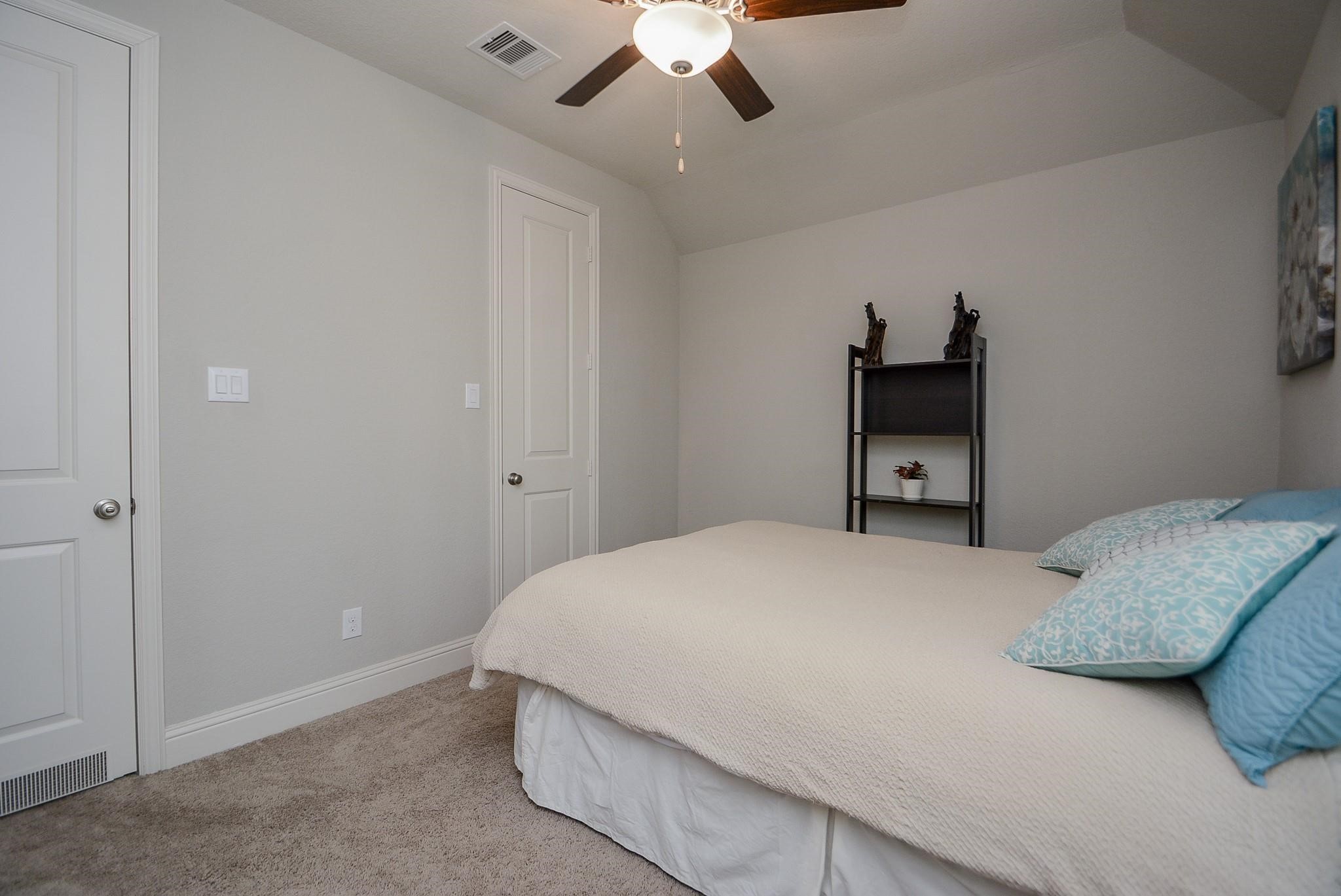 114 Silver Sky Street Conroe, TX 77304 - Photo 26 of 36 a bedroom with a bed and a tv