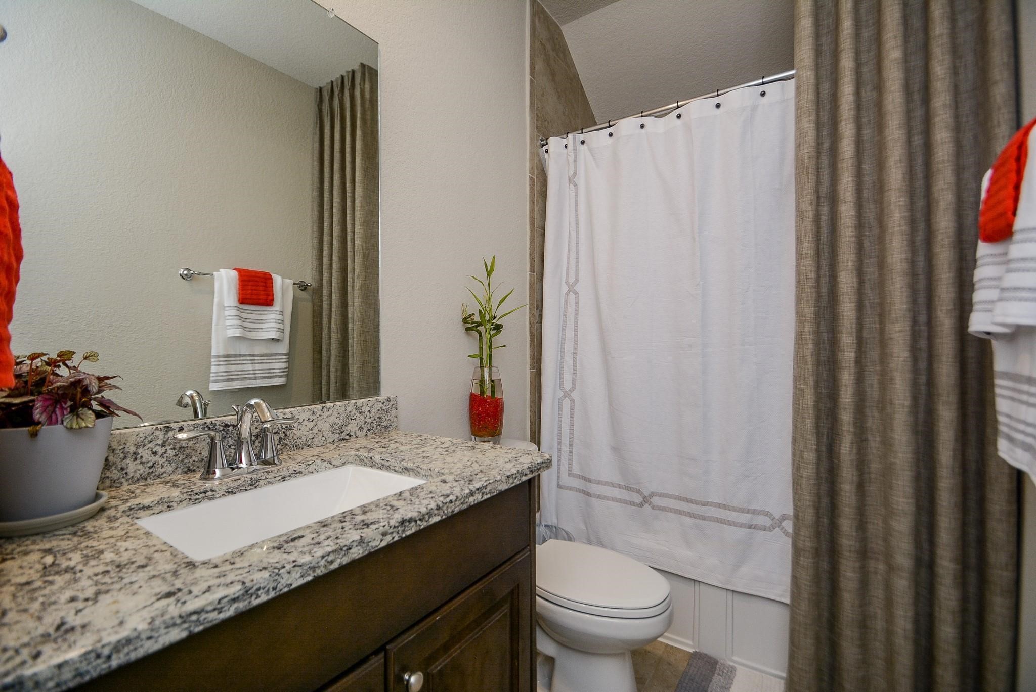 114 Silver Sky Street Conroe, TX 77304 - Photo 28 of 36 a bathroom with a granite countertop sink and a mirror