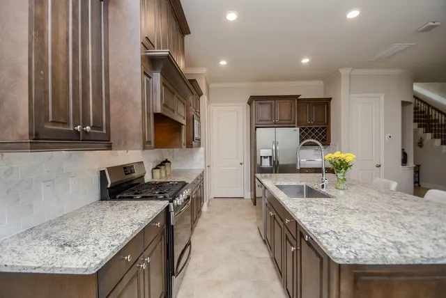 a kitchen with stainless steel appliances granite countertop sink stove and refrigerator
