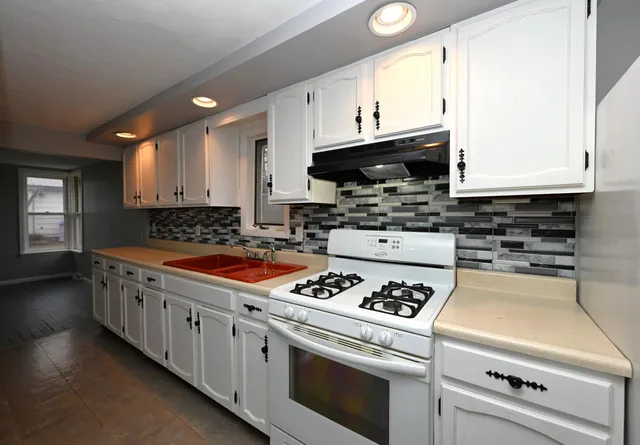 a kitchen with stainless steel appliances granite countertop a stove a sink and a microwave