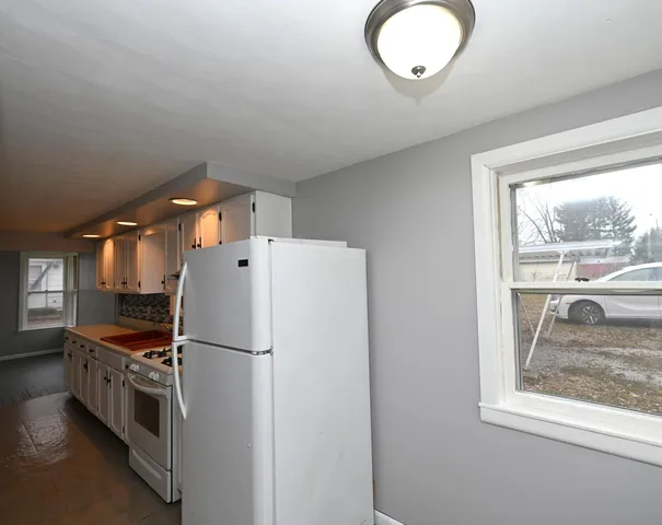 a kitchen with refrigerator a stove a sink and a window
