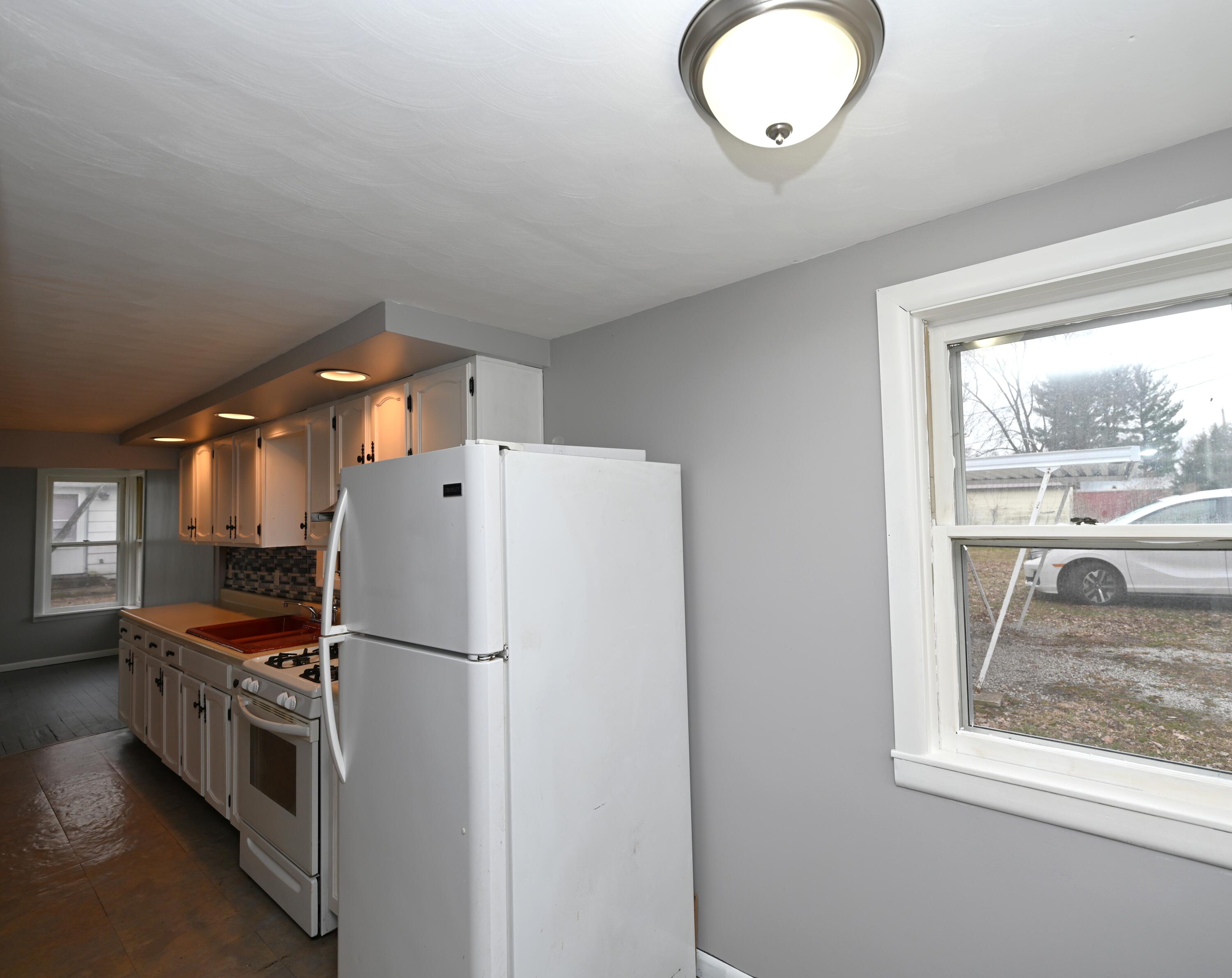 411 West Jefferson Street Winamac, IN 46996 - Photo 13 of 23 a kitchen with refrigerator a stove a sink and a window