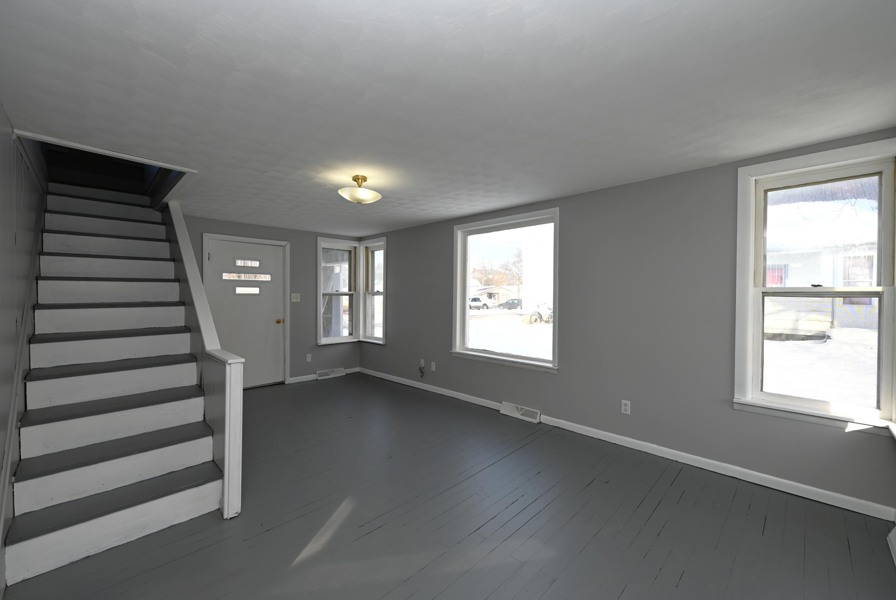 411 West Jefferson Street Winamac, IN 46996 - Photo 5 of 23 an empty room with wooden floor and windows