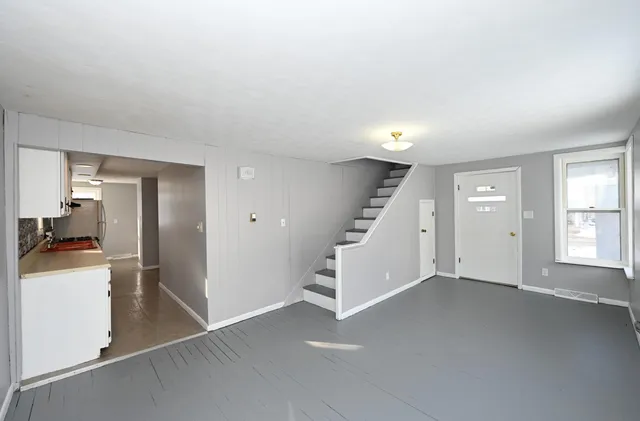 an empty room with a kitchen and a sink