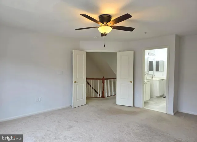 an empty room with fan and windows
