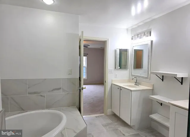 a bathroom with a bathtub a sink and mirror