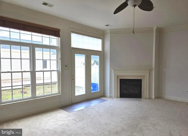 a view of an empty room with a fireplace and a window