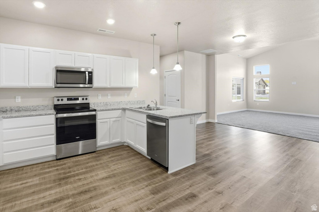 1838 West 300th Street South, Unit B Mapleton, UT 84664 - Photo 15 of 51 Modern kitchen featuring white cabinetry, stainless steel appliances, speckled countertops, and wood-finish flooring
