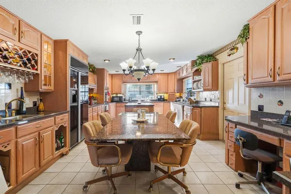 a kitchen with kitchen island granite countertop wooden cabinets and stainless steel appliances