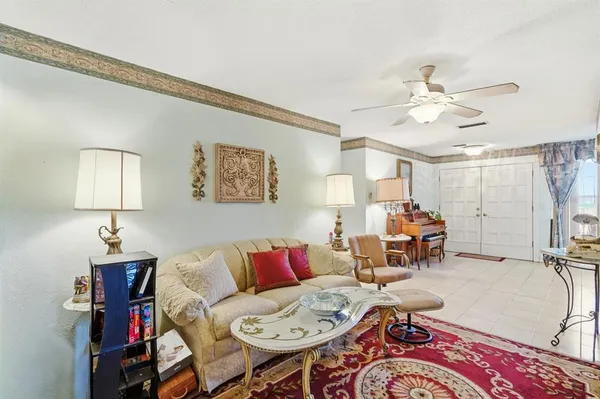 a living room with furniture a chandelier and a flat screen tv