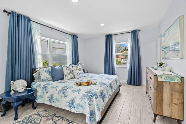 a bedroom with a bed and large windows