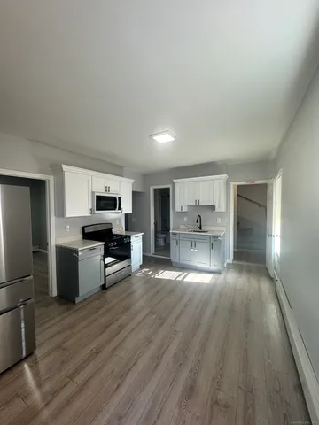a view of kitchen with sink microwave and refrigerator