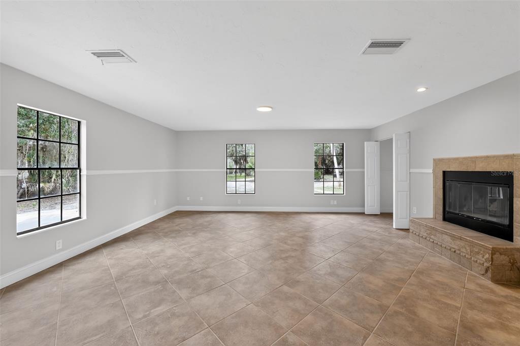 4570 Hidden River Road Sarasota, FL 34240 - Photo 24 of 45 an empty room with windows and fireplace