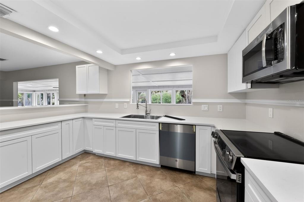 4570 Hidden River Road Sarasota, FL 34240 - Photo 30 of 45 a kitchen with stainless steel appliances a sink stove and microwave