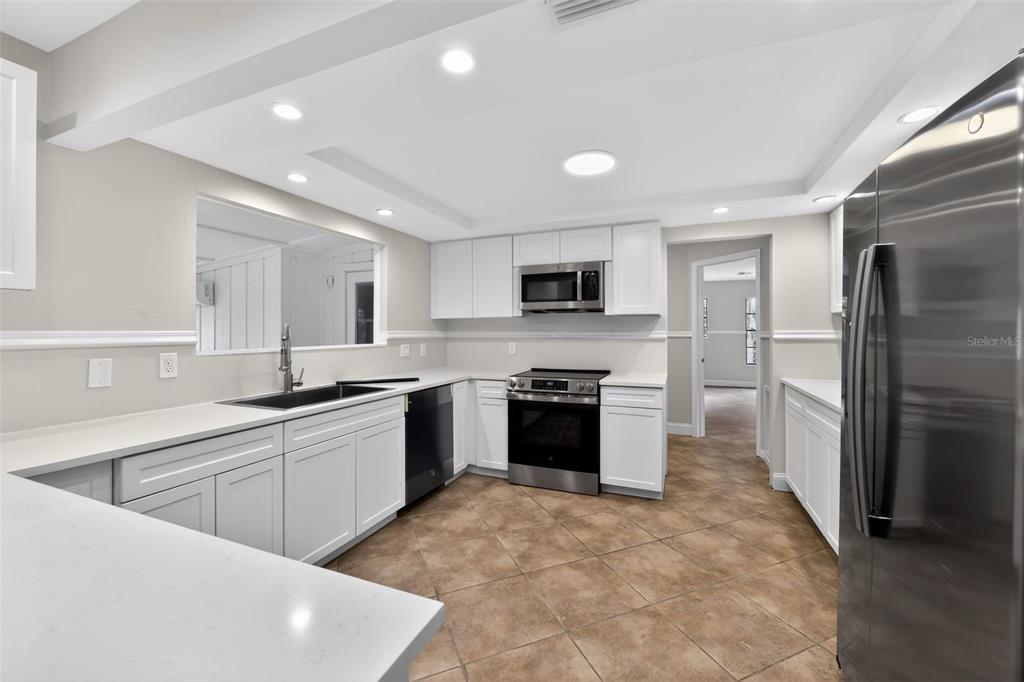 4570 Hidden River Road Sarasota, FL 34240 - Photo 31 of 45 a large kitchen with stainless steel appliances granite countertop a refrigerator and a sink