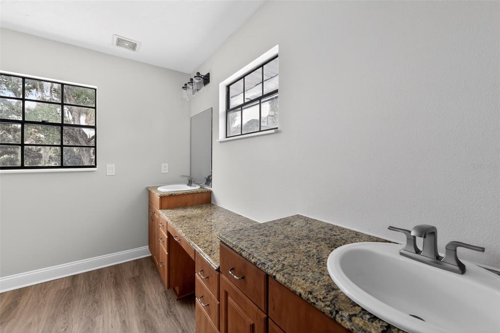4570 Hidden River Road Sarasota, FL 34240 - Photo 38 of 45 a bathroom with a granite countertop sink and a mirror