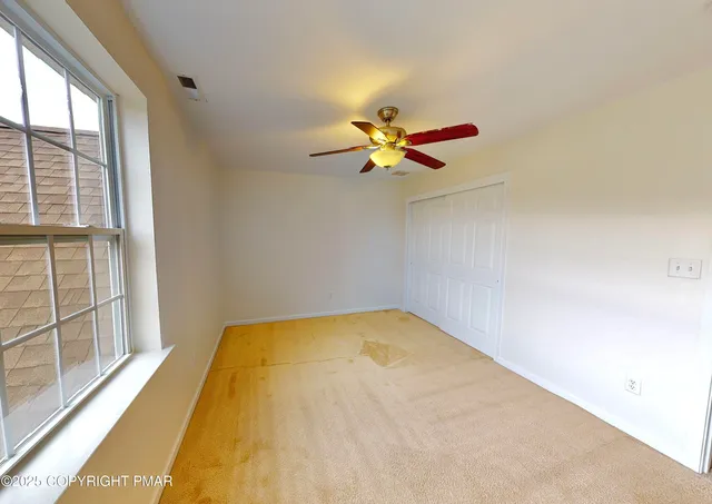 a view of a room with a ceiling fan and a large window