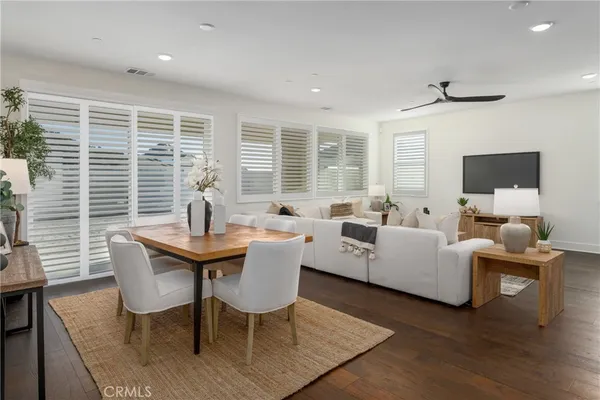a living room with furniture a large window and a wooden floor