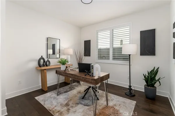 a view of a workspace with furniture and a window