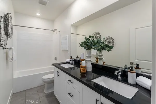a bathroom with a double vanity sink toilet and shower