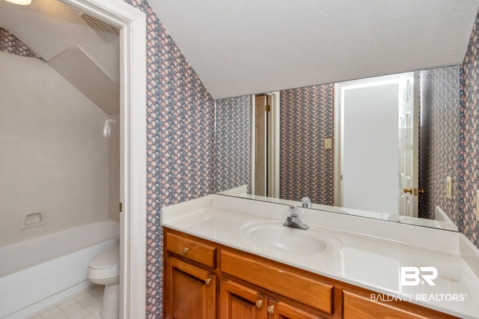 105 McHugh Lane Mobile, AL 36608 - Photo 21 of 30 Bathroom with wallpapered walls, a textured ceiling, vanity, light tile patterned flooring, and shower / bath combination