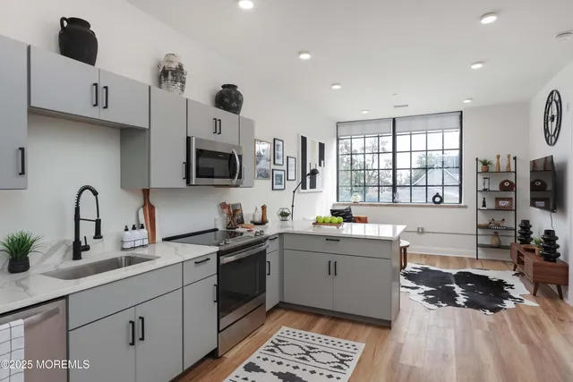 a kitchen with stainless steel appliances a sink stove and cabinets