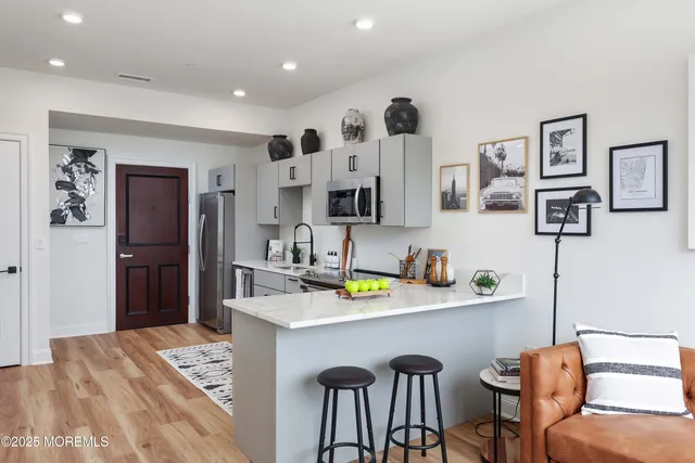 a kitchen with stainless steel appliances kitchen island granite countertop a refrigerator and a sink