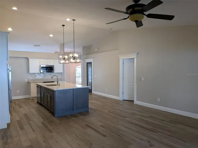 a kitchen with wooden floors and a view of living room