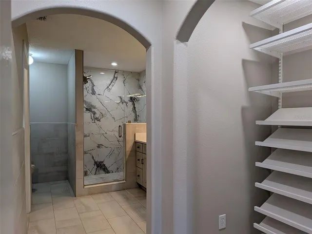 a view of a hallway with wooden floor and a bathroom