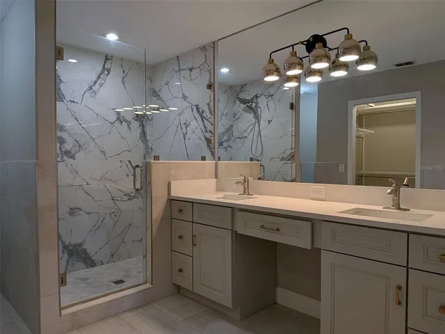 a bathroom with a double vanity sink mirror and shower