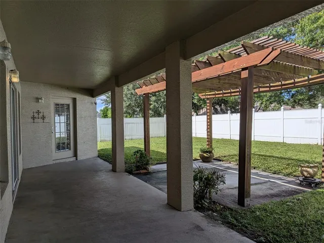 a view of a patio with table and chairs under an umbrella
