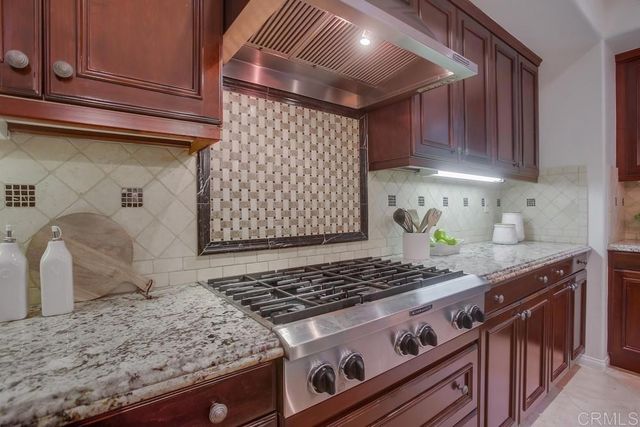 a kitchen with granite countertop stove and cabinets