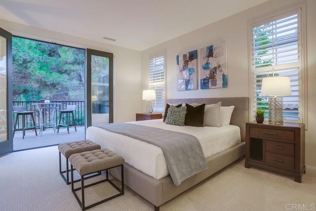 a bedroom with a bed and a large window