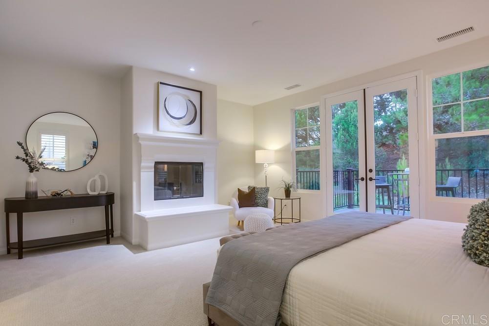 7618 Circulo Sequoia Carlsbad, CA 92009 - Photo 23 of 45 a bedroom with a bed a clock and a large window with outer view
