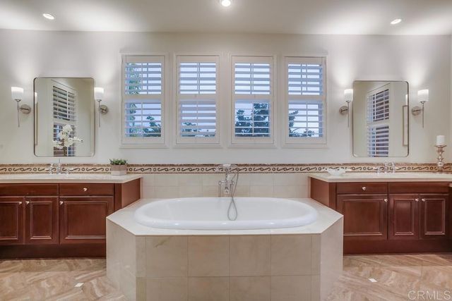 a bathroom with a granite countertop sink and a bathtub