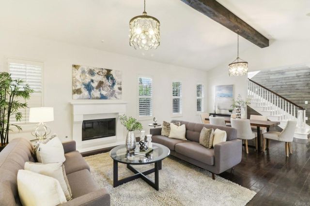 a living room with furniture a chandelier and a fireplace