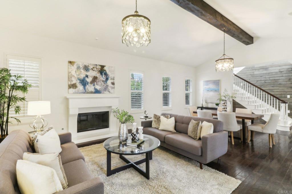 7618 Circulo Sequoia Carlsbad, CA 92009 - Photo 4 of 45 a living room with furniture a chandelier and a fireplace