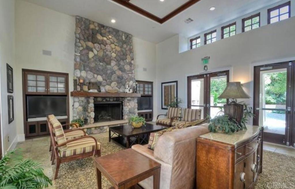 7618 Circulo Sequoia Carlsbad, CA 92009 - Photo 41 of 45 a living room with furniture a fireplace and a floor to ceiling window