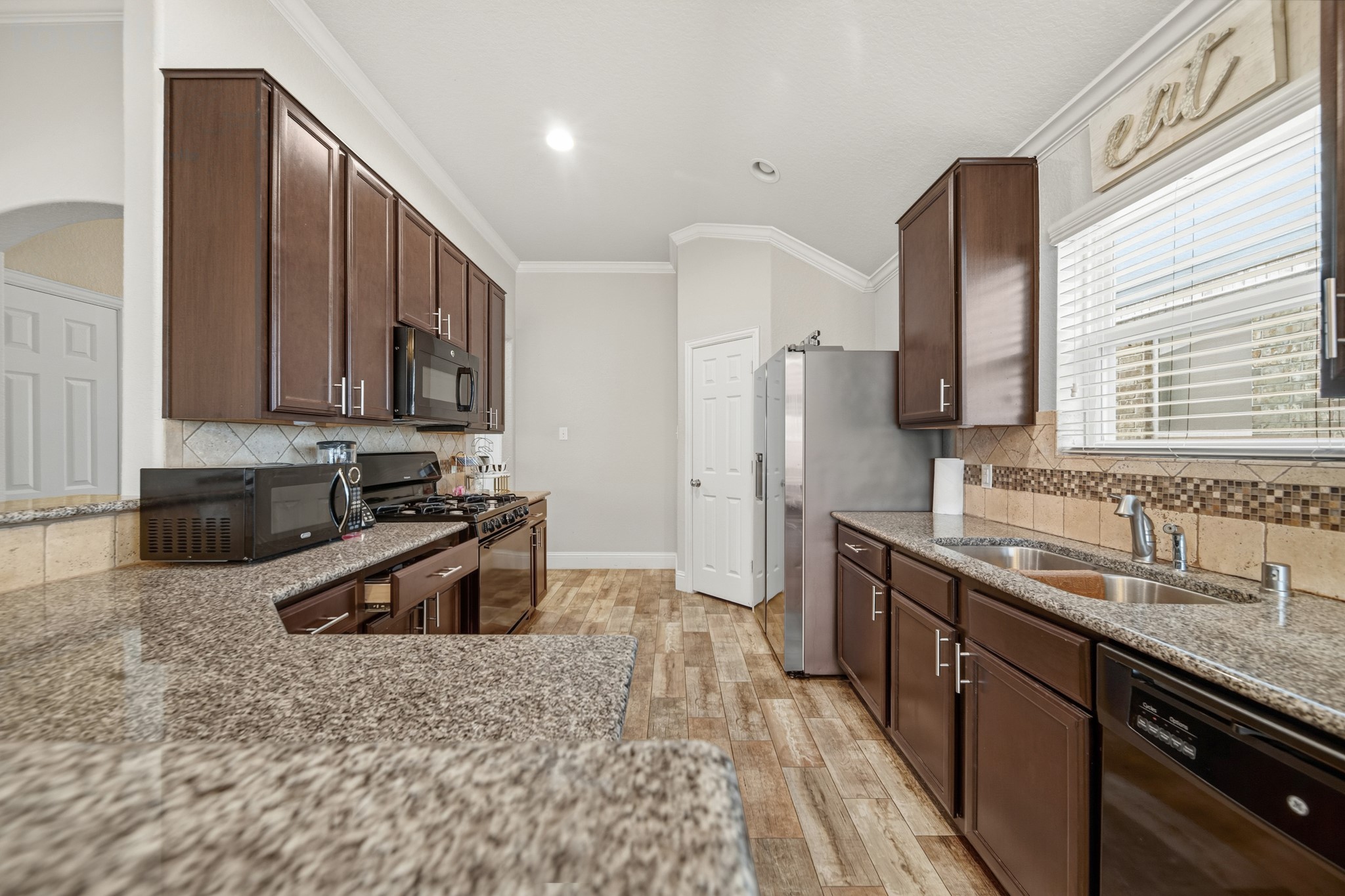 29446 Ridge Clearing Trail Spring, TX 77386 - Photo 13 of 28 Well-appointed kitchen featuring granite countertops, dark cabinetry, and ample workspace.