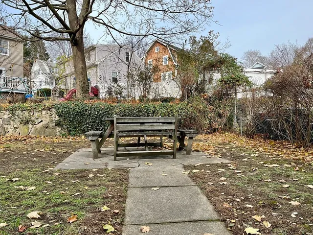 a view of a park with wooden bench