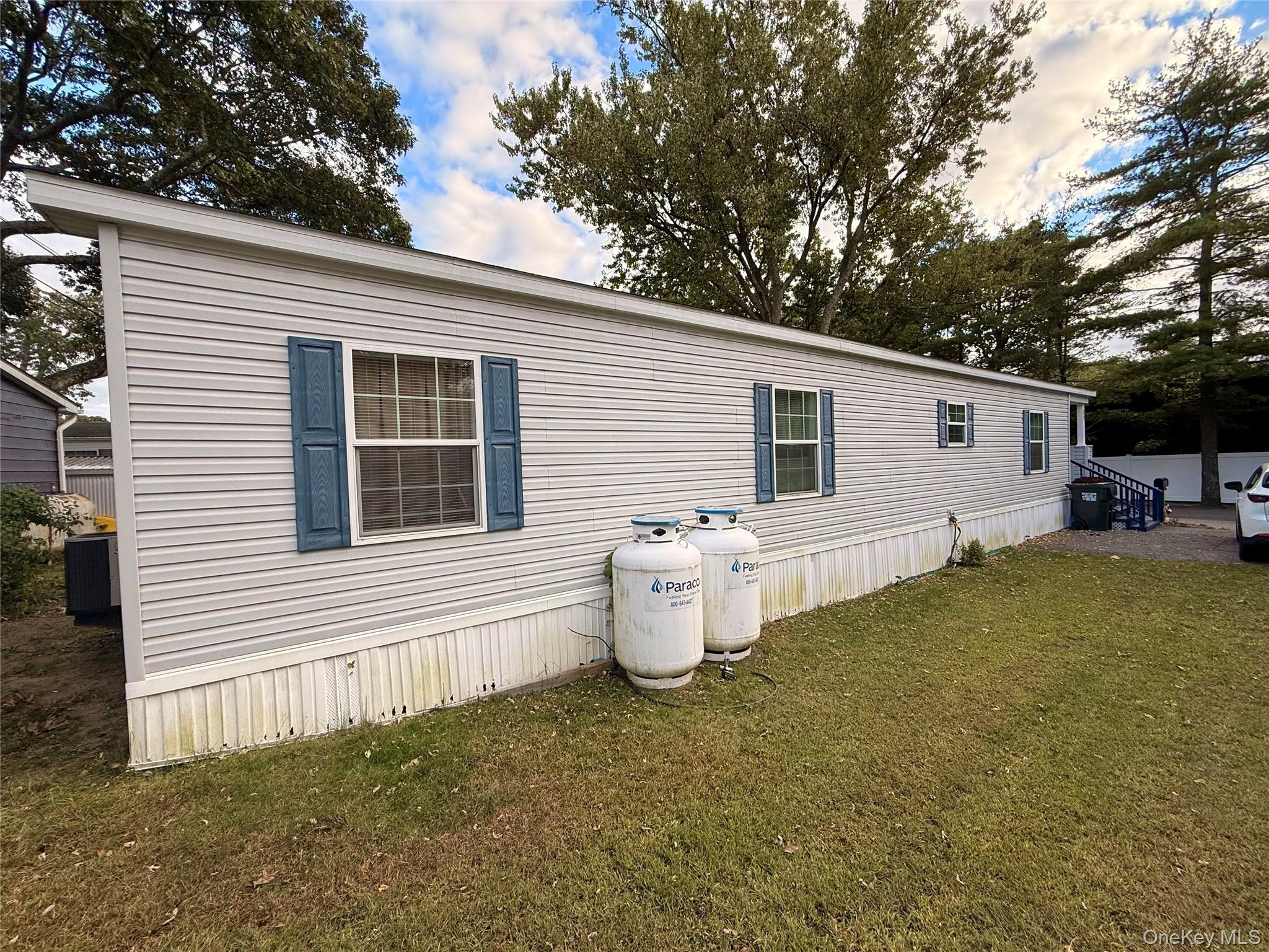37 Hubbard Avenue, Unit 95 Riverhead, NY 11901 - Photo 4 of 14 View of property exterior featuring a yard