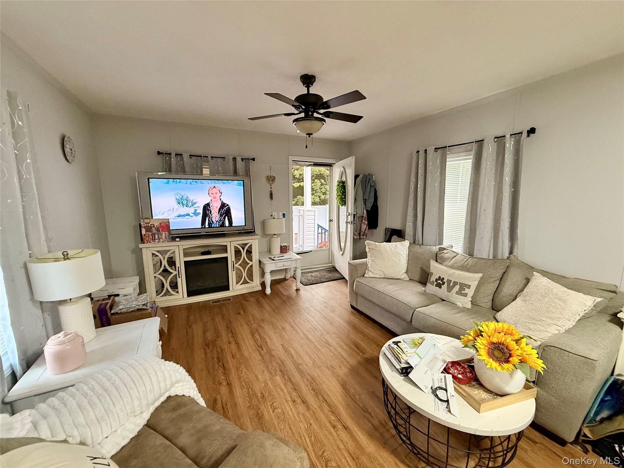 37 Hubbard Avenue, Unit 95 Riverhead, NY 11901 - Photo 6 of 14 Living room featuring wood finished floors and a ceiling fan