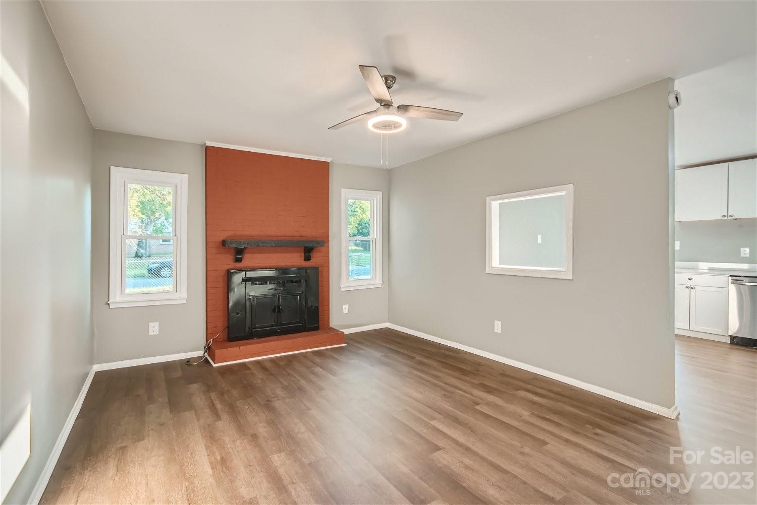 7438 Bramblewood Drive Charlotte, NC 28217 - Photo 11 of 27 a view of a room with wooden floor ceiling fan and windows