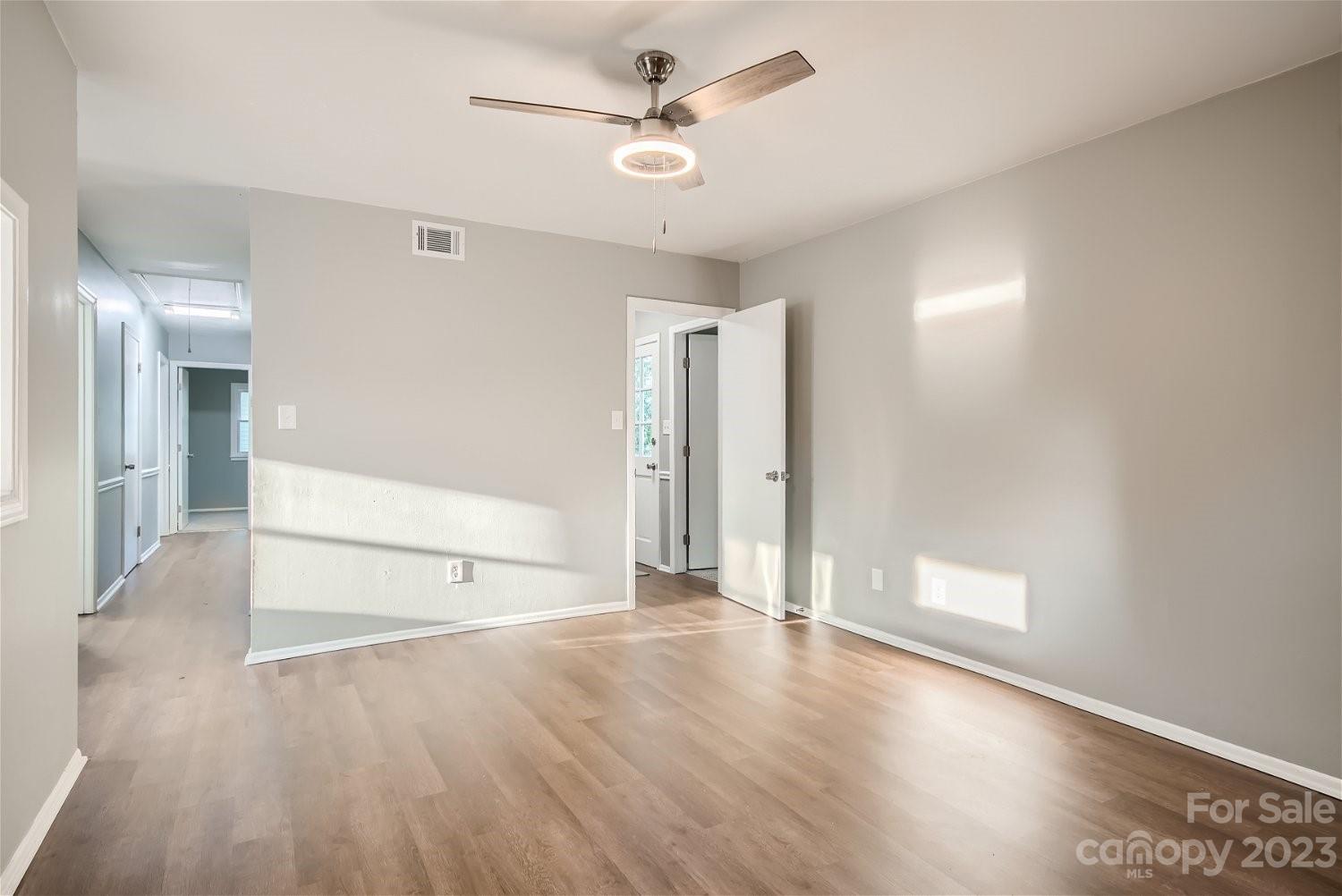 7438 Bramblewood Drive Charlotte, NC 28217 - Photo 12 of 27 a view of empty room with wooden floor and ceiling fan