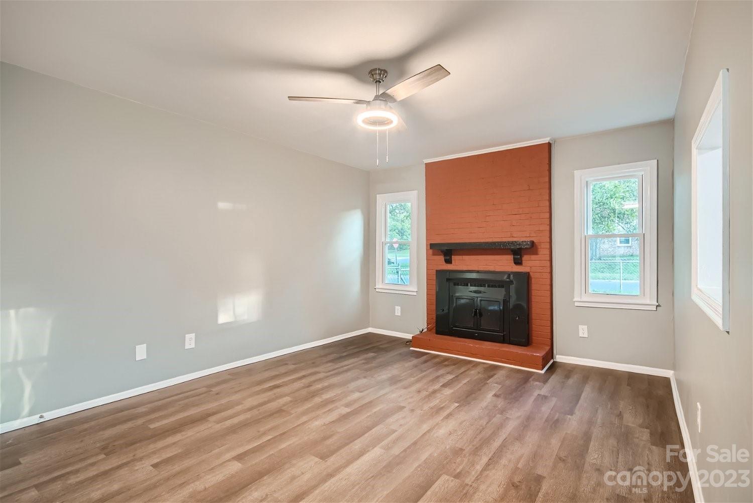 7438 Bramblewood Drive Charlotte, NC 28217 - Photo 14 of 27 a view of an empty room with wooden floor fireplace and a window