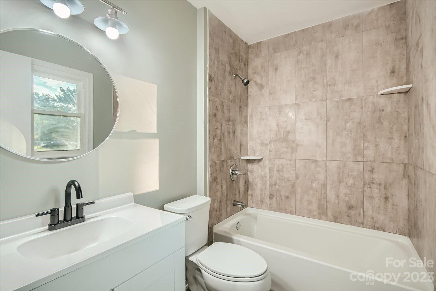 7438 Bramblewood Drive Charlotte, NC 28217 - Photo 19 of 27 a bathroom with a bathtub a mirror a sink and a shower